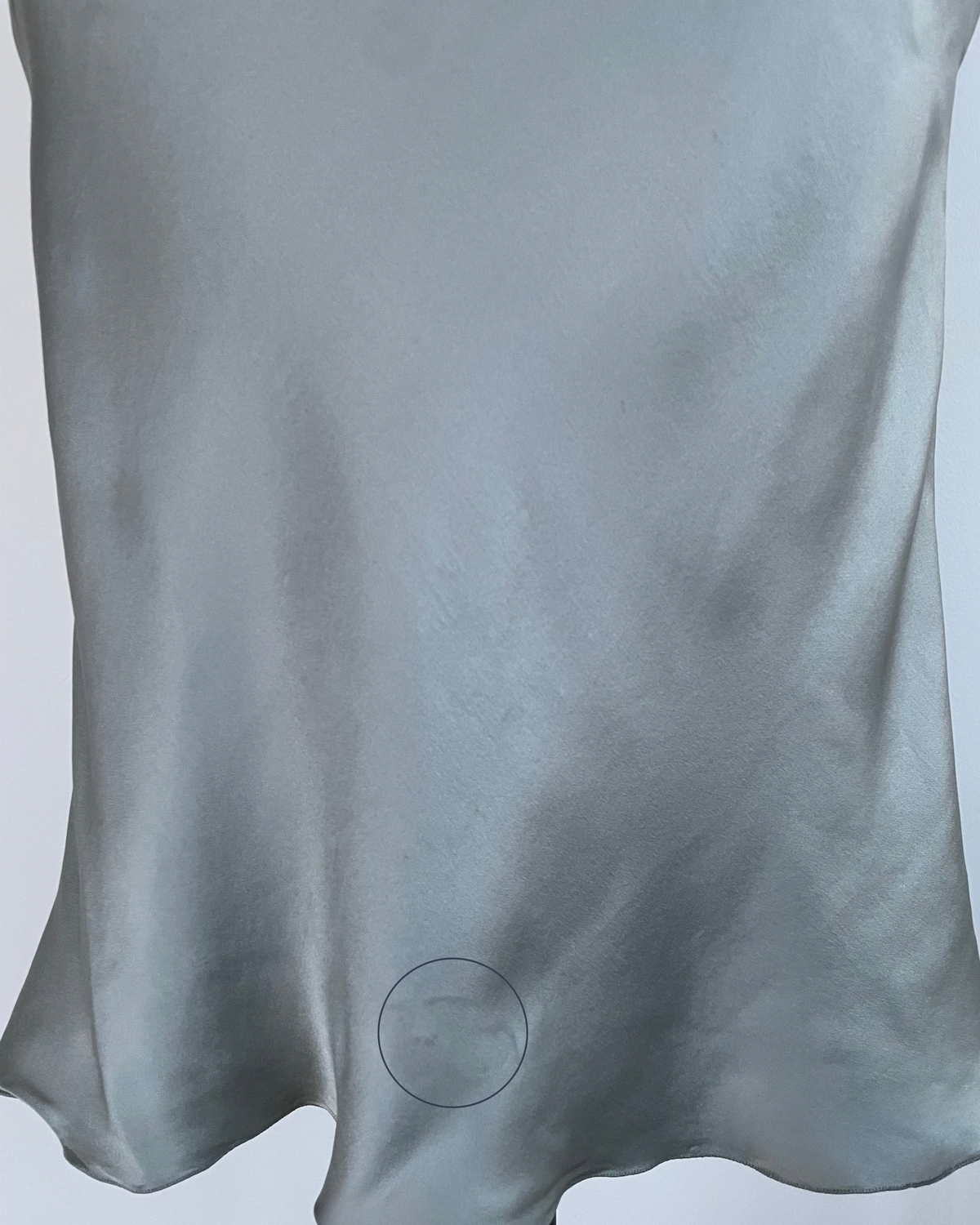 Close-up of gray-blue silk skirt fabric and hem drape